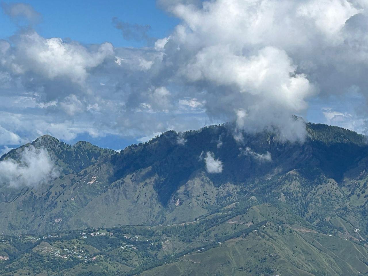 Cloud spilling across the forested ridge